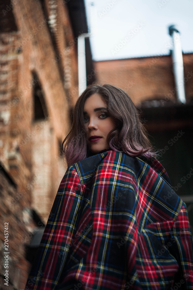beautiful brunette in a plaid jacket at the brick wall beautiful brunette in a plaid jacket at the brick wall