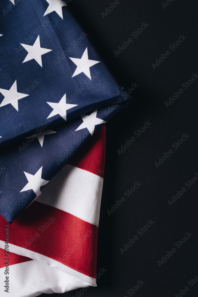 Fototapeta premium folded united states national flag isolated on black, memorial day concept