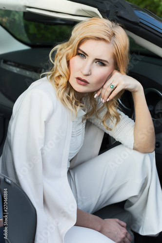 Portrait of an attractive woman, shot on location and sitting in an open top car