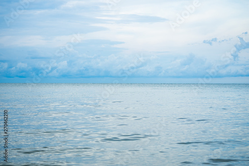 Landscape horizontal skyline of ocean and calm sea with clouded sky in background