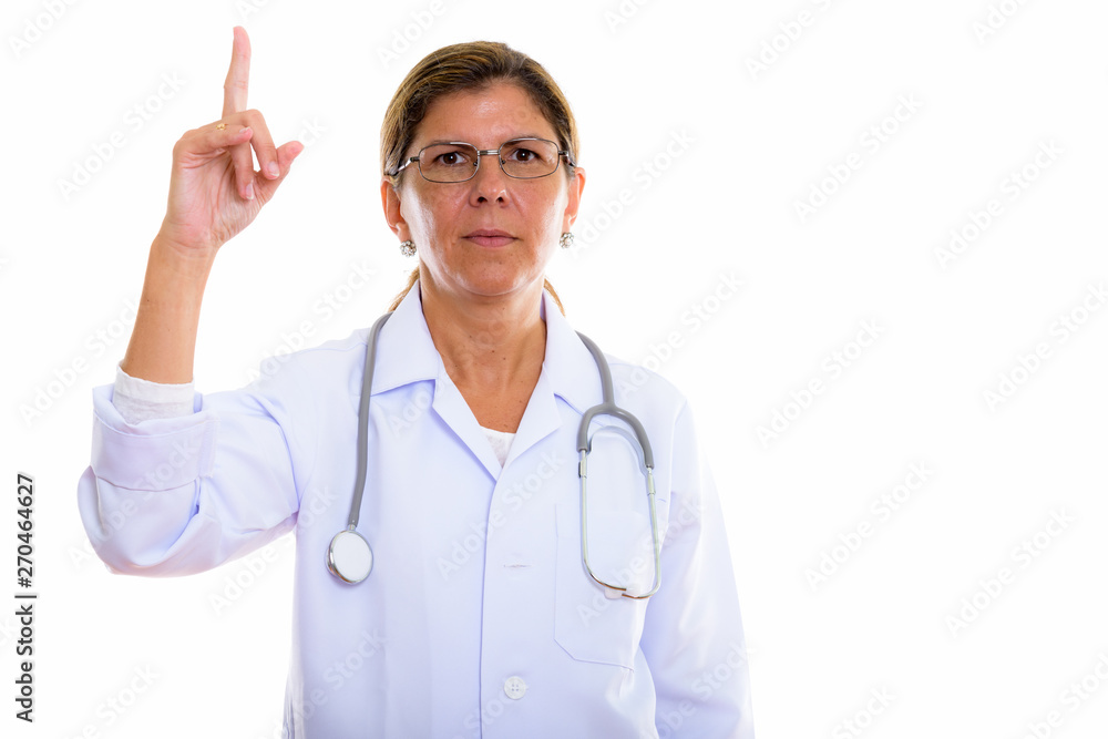 Studio shot of mature beautiful woman doctor pointing finger up Studio shot of mature beautiful woman doctor pointing finger up