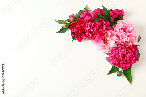 Flat lay composition with beautiful peonies on white background, space for text and top view