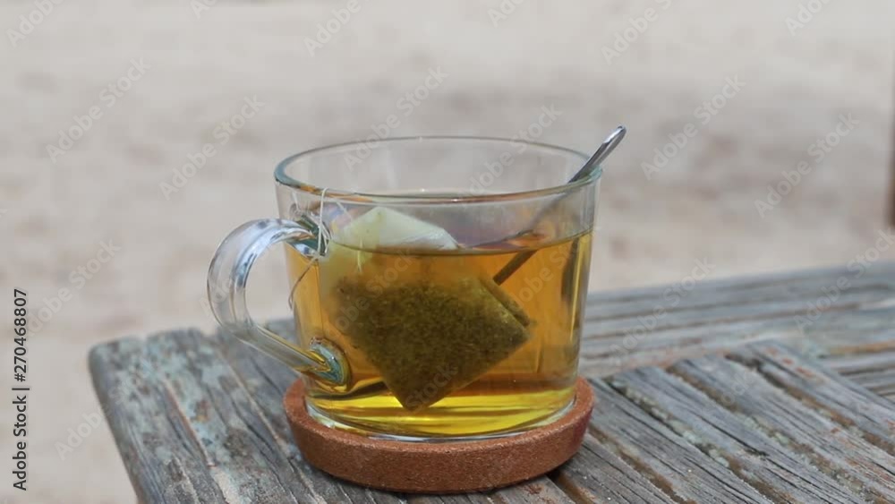 a cup of tea on wooden table on beach a cup of tea on wooden table on beach