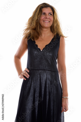 Studio shot of mature happy woman smiling and thinking with hand
