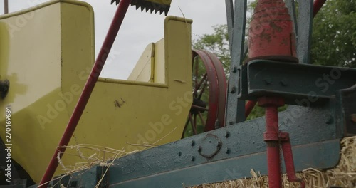 Vintage machine pressing straw into bales