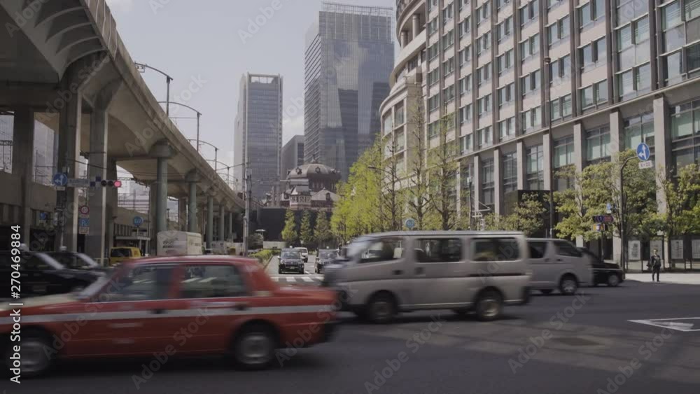 Vehicles passing under train bridge near Tokyo Station, Japan - Sunny day - Wide steadicam shot Vehicles passing under train bridge near Tokyo Station, Japan - Sunny day - Wide steadicam shot