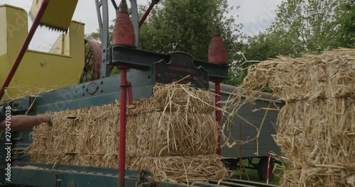 machine pressing straw into bales