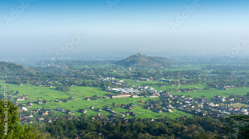 Aerial city view from a hill in the morning with a blue sky background