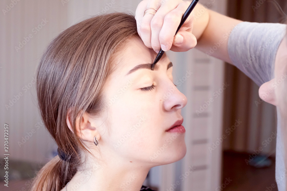 Fototapeta premium Make-up artist painting beautiful girl eyeshadows.