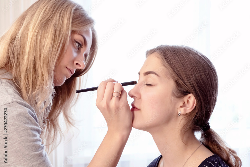 Make-up artist painting beautiful girl eyeshadows. Make-up artist painting beautiful girl eyeshadows.