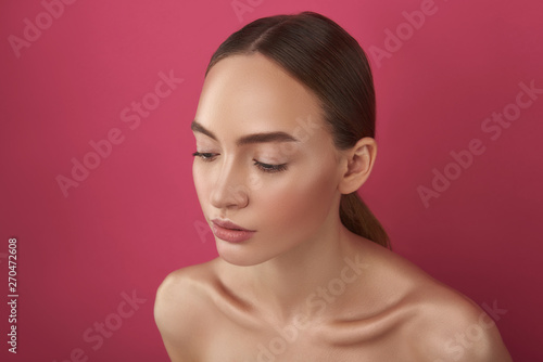 Beautiful naked lady with perfect skin posing against pink background