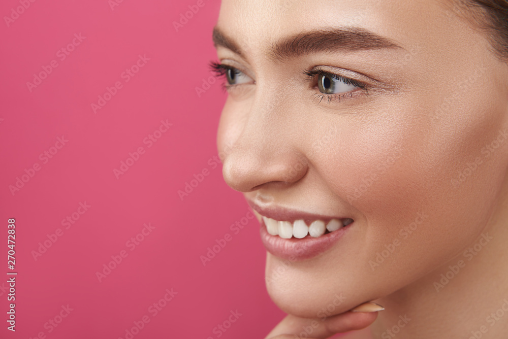 Obraz premium Joyful lady with perfect skin standing against pink background