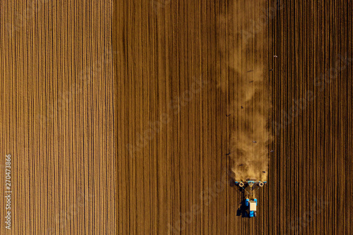 Tractor in field on a farm, aerial view
