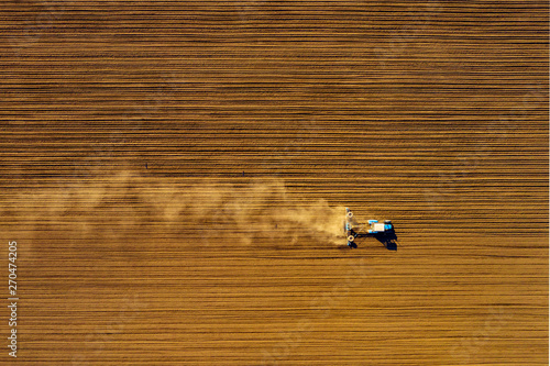 Tractor in field on a farm, aerial view