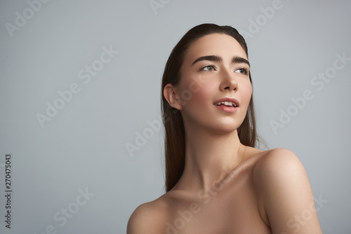 Cheerful nude woman is isolated on grey background