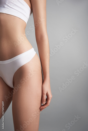 Slim woman in lingerie isolated on grey background