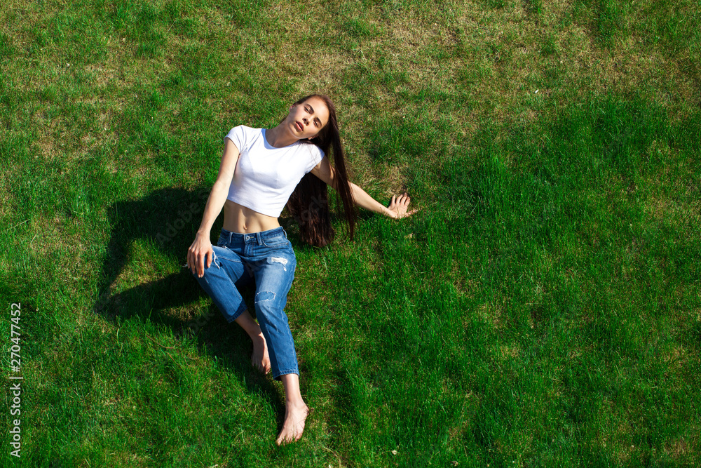 Portrait of a young beautiful girl resting on the lawn in the park Portrait of a young beautiful girl resting on the lawn in the park