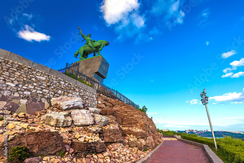 Walking path around the stone monument to Salawat Yulaev in a summer sunny day with blue sky, bottom view in front of the rocks. Salavat Yulayev, Ufa, Bashkortostan, Russia.