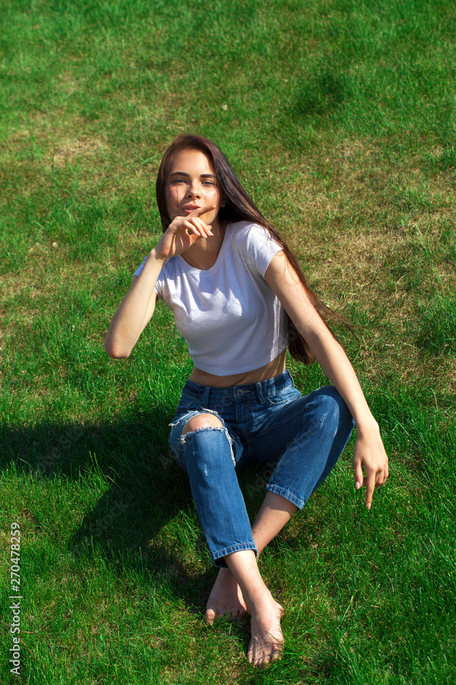 Portrait of a young beautiful girl resting on the lawn in the park Portrait of a young beautiful girl resting on the lawn in the park