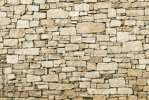 Old beige stone wall background texture