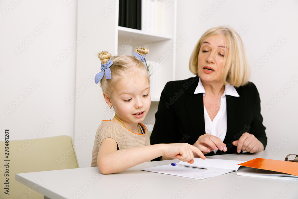 Teacher with little girl. Doing homework concept Teacher with little girl. Doing homework concept