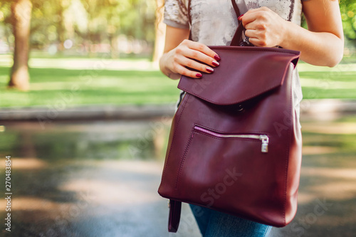 Young woman holding stylish leather backpack. Spring female clothes and accessories. Fashion