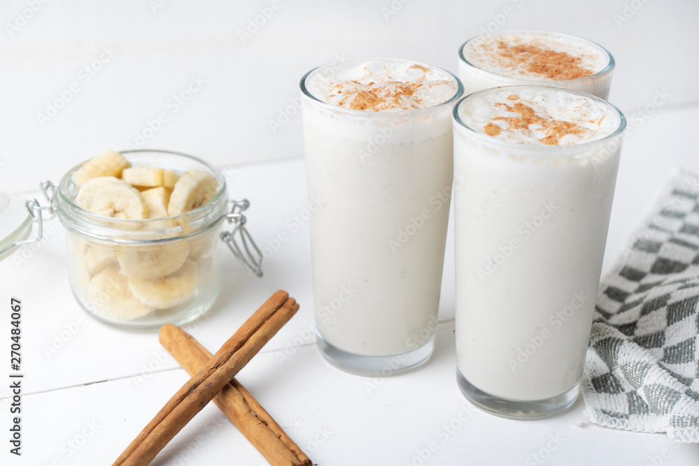 Banana smothie or milkshake with cinnamon on white background Banana smothie or milkshake with cinnamon on white background
