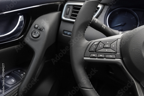 multimedia control panel  on the steering wheel of a modern car © godlikeart