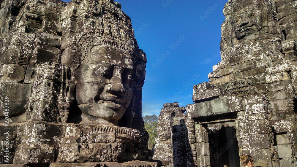 Giant stone face in an ancient temple. Sculpture of face in Bayon Temple in Cambodia, Asia. Asian Temple with artwork. Jungle temple ruin near Angkor Wat