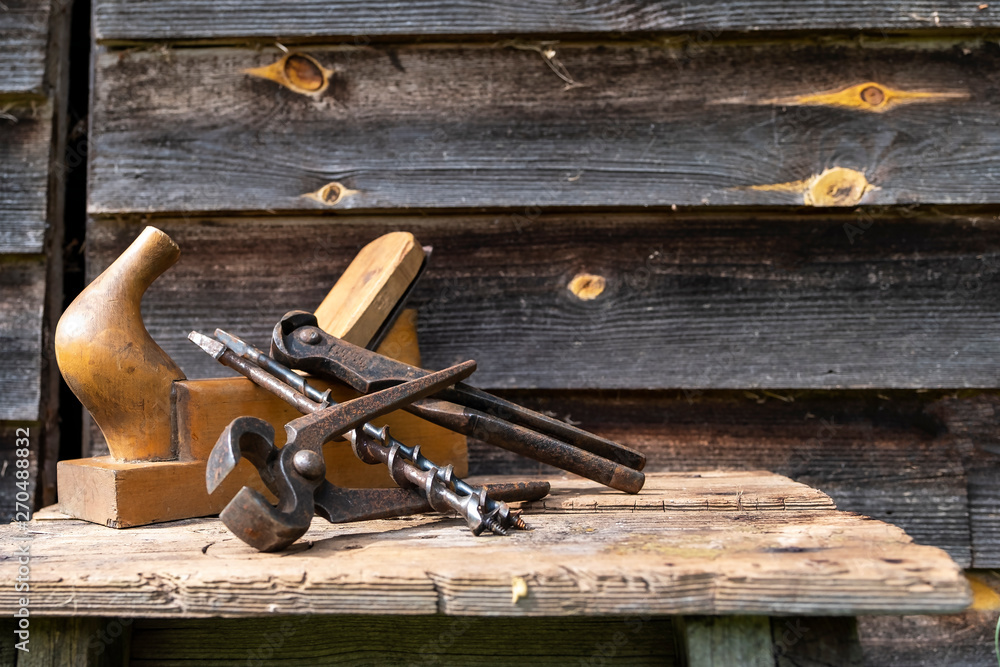 Antique hand tools plane pincers and drills. Old brown boards. Copy space Antique hand tools plane pincers and drills. Old brown boards. Copy space