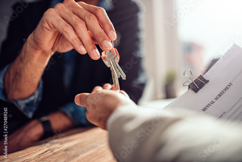 Real estate agent passing keys to his client photo