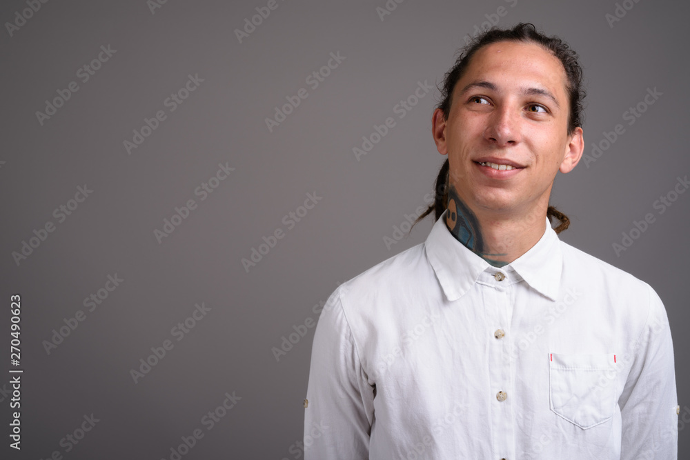 Young businessman with dreadlocks against gray background Young businessman with dreadlocks against gray background