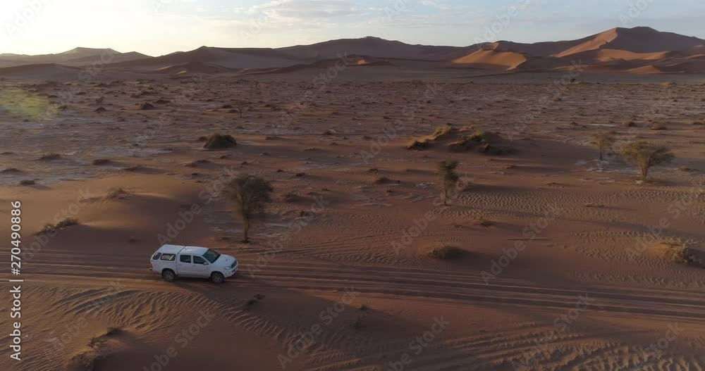 Aerial view of tourist vehicle driving through soft sand to Sossusvlei Aerial view of tourist vehicle driving through soft sand to Sossusvlei