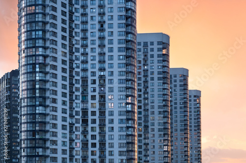 Contemporary residential building exterior in the evening. Modern block with beautiful flats illuminated by the evening sun. Modern apartment residential building in the city.