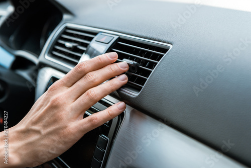 Foto cropped view of man touching air conditioner switch in car