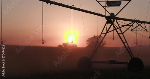 Close-up backlit view of centre pivot irrigatiing vegetables photo