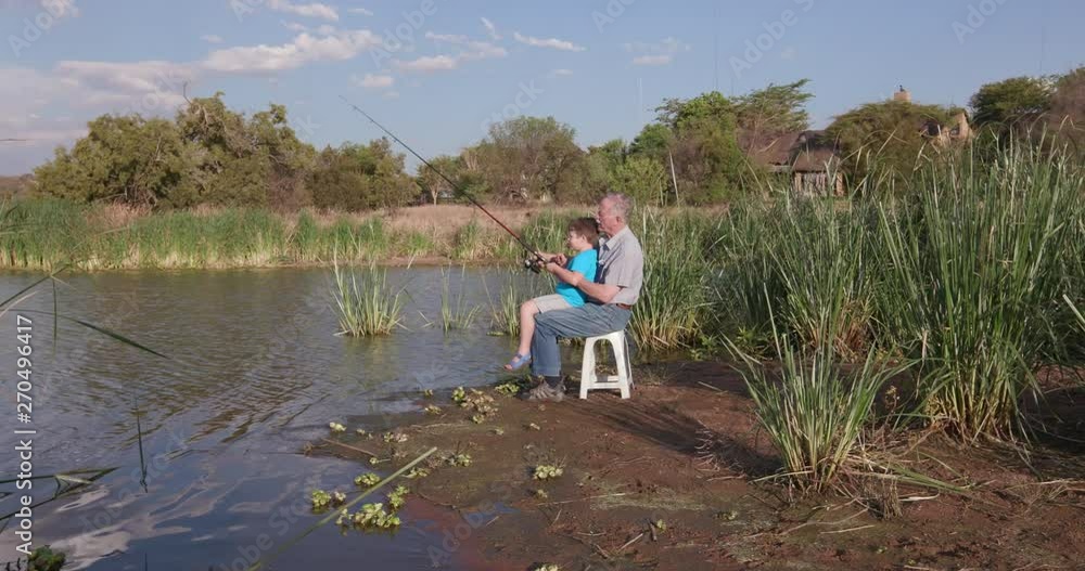 Grandfather and grandson fishing at a small lake Grandfather and grandson fishing at a small lake