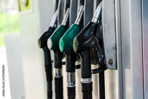 Selective focus of green and black fuel pumps at gas station