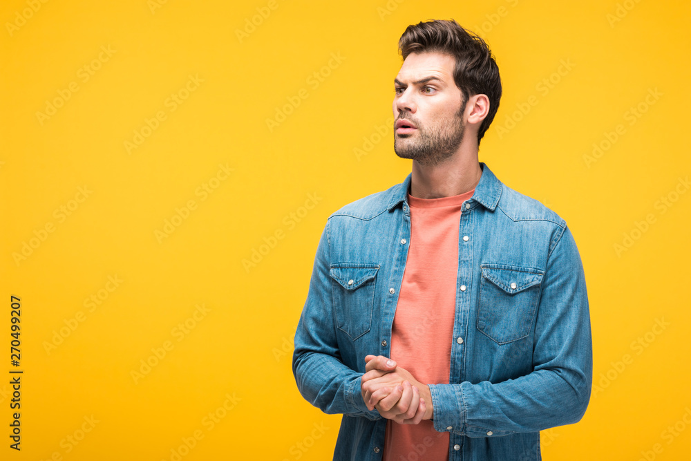 confused handsome man with clenched hands Isolated On yellow with copy space confused handsome man with clenched hands Isolated On yellow with copy space