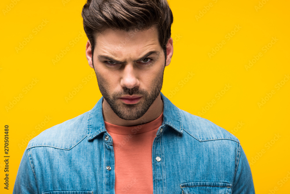 Obraz premium handsome aggressive man looking at camera Isolated On yellow