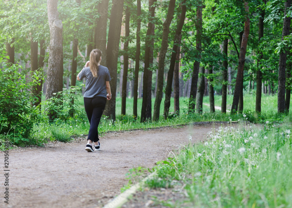 Fat girl is running in the summer forest. Woman with excess weight runs in the green city park, active healthy lifestyle . Close up. Fat girl is running in the summer forest. Woman with excess weight runs in the green city park, active healthy lifestyle . Close up.