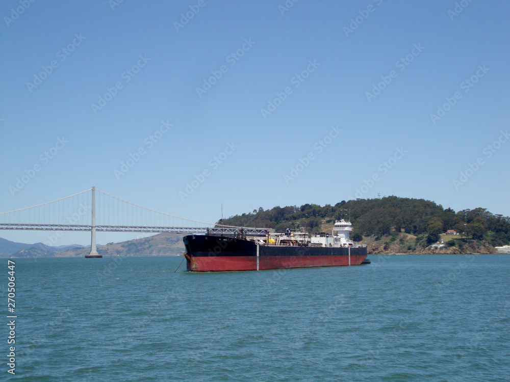 Cargo Boat in front of San Francisco Bay Bridge and Island
