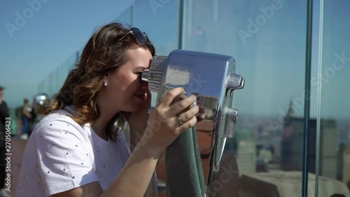 Young woman using scope at observation deck viewpoint
