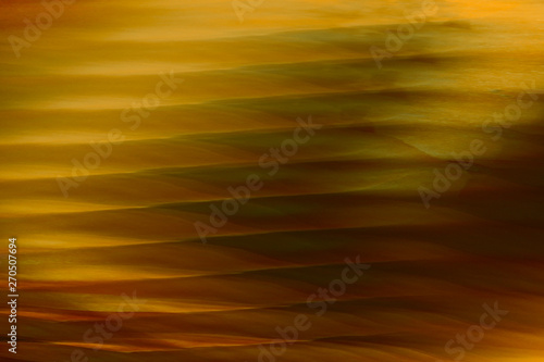 Abstract blurred background with gold or brass lines and curves and striped pattern