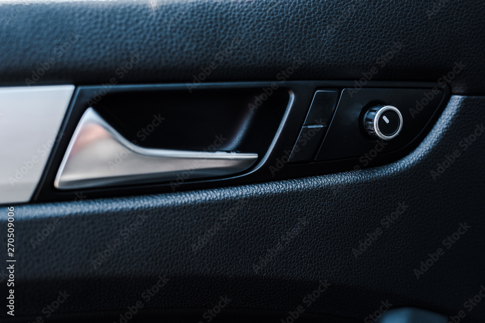 metallic automobile door handle near buttons in modern car