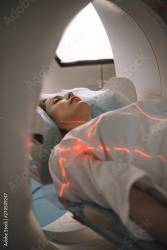 Photos young woman lying on ct scanner bed during tomography diagnostics in hospital