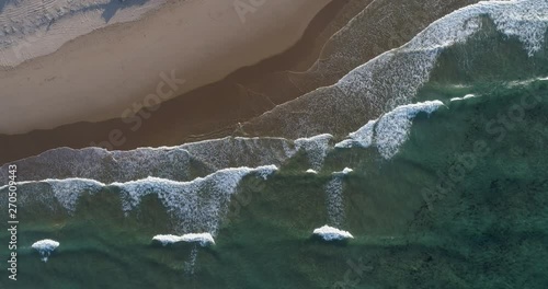 Aerial static view of waves crashing onto the shore photo