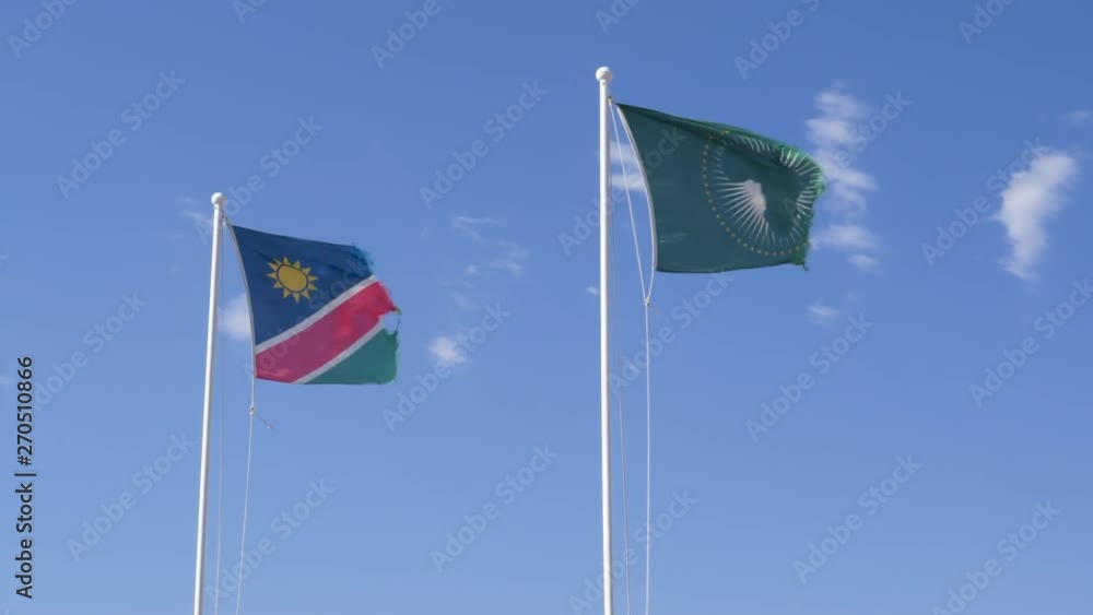 4K view of the Namibian and the African Union flags shredded by the strong and persistant winds of the Namib desert, Namibia 4K view of the Namibian and the African Union flags shredded by the strong and persistant winds of the Namib desert, Namibia