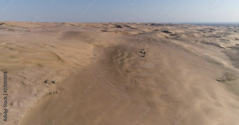 4K aerial zoom in view of 4x4 vehicles driving along the picturesque sand dunes of the Skeleton Coast, Namib desert, Namibia 4K aerial zoom in view of 4x4 vehicles driving along the picturesque sand dunes of the Skeleton Coast, Namib desert, Namibia