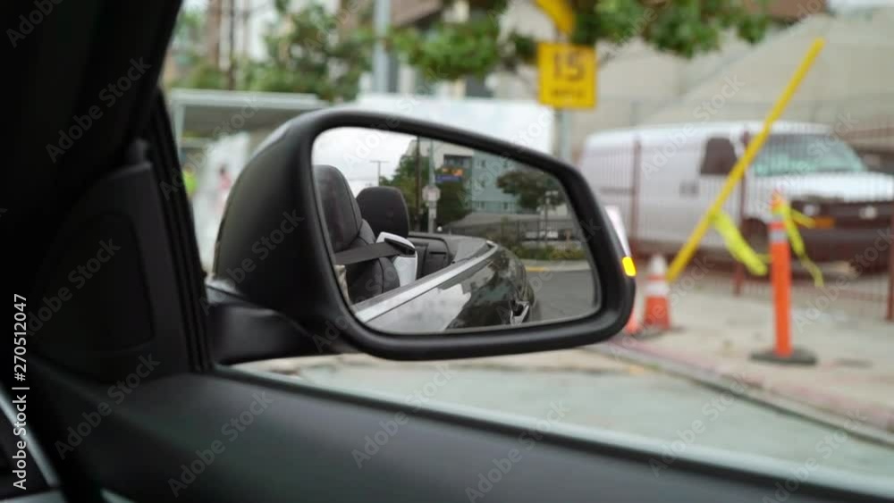 Driving car in a city, rear view mirror Driving car in a city, rear view mirror